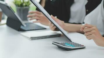 Financial analysts analyze business financial reports on a digital tablet planning investment project during a discussion at a meeting of corporate showing the results of their successful teamwork. video