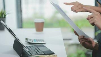 Financial analysts analyze business financial reports on a digital tablet planning investment project during a discussion at a meeting of corporate showing the results of their successful teamwork. video