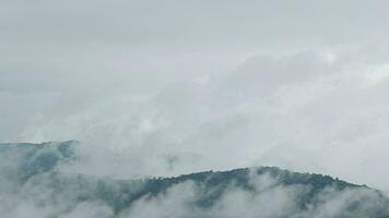 Mountain range with visible silhouettes through the morning blue fog. video