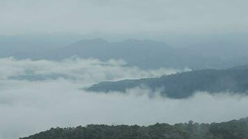 Mountain range with visible silhouettes through the morning blue fog. video