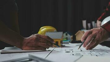 costruzione e struttura concetto di ingegnere Lavorando disegno su planimetria incontro per progetto Lavorando con compagno su modello edificio e ingegneria utensili nel Lavorando luogo, costruzione concetto. video