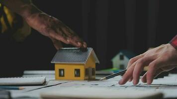 costruzione e struttura concetto di ingegnere Lavorando disegno su planimetria incontro per progetto Lavorando con compagno su modello edificio e ingegneria utensili nel Lavorando luogo, costruzione concetto. video