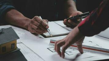 costruzione e struttura concetto di ingegnere Lavorando disegno su planimetria incontro per progetto Lavorando con compagno su modello edificio e ingegneria utensili nel Lavorando luogo, costruzione concetto. video