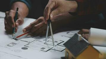 costruzione e struttura concetto di ingegnere Lavorando disegno su planimetria incontro per progetto Lavorando con compagno su modello edificio e ingegneria utensili nel Lavorando luogo, costruzione concetto. video