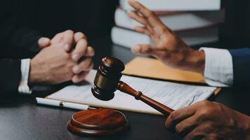 Business and lawyers discussing contract papers with brass scale on desk in office. Law, legal services, advice, justice and law concept picture with film grain effect video