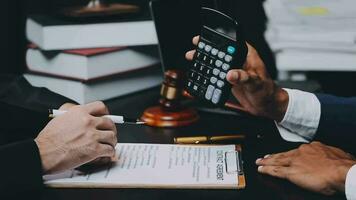 Business and lawyers discussing contract papers with brass scale on desk in office. Law, legal services, advice, justice and law concept picture with film grain effect video