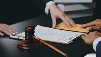 Business and lawyers discussing contract papers with brass scale on desk in office. Law, legal services, advice, justice and law concept picture with film grain effect video