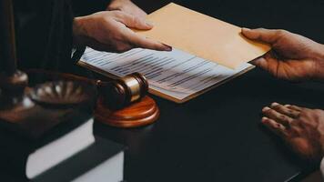 Business and lawyers discussing contract papers with brass scale on desk in office. Law, legal services, advice, justice and law concept picture with film grain effect video