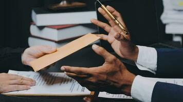 Business and lawyers discussing contract papers with brass scale on desk in office. Law, legal services, advice, justice and law concept picture with film grain effect video