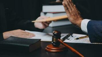 Business and lawyers discussing contract papers with brass scale on desk in office. Law, legal services, advice, justice and law concept picture with film grain effect video