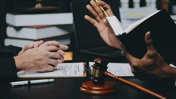 Business and lawyers discussing contract papers with brass scale on desk in office. Law, legal services, advice, justice and law concept picture with film grain effect video