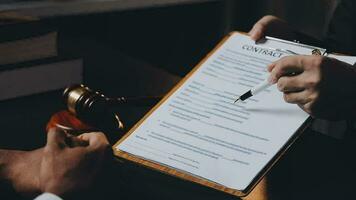 zaken en advocaten bespreken contractpapieren met koperen schaal op bureau in kantoor. wet, juridische diensten, advies, rechtvaardigheid en wet concept foto met film grain effect video