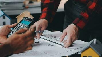 reunión de trabajo en equipo de ingenieros, trabajo de dibujo en la reunión de planos para el trabajo del proyecto con un socio en la construcción de modelos y herramientas de ingeniería en el concepto de sitio de trabajo, construcción y estructura. video