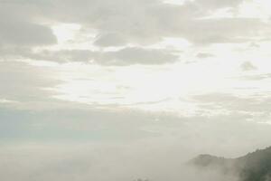 Mountain range with visible silhouettes through the morning blue fog. photo