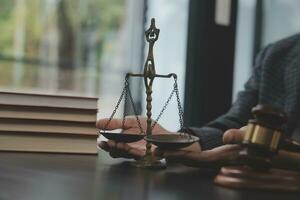 Business and lawyers discussing contract papers with brass scale on desk in office. Law, legal services, advice, justice and law concept picture with film grain effect photo