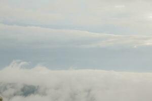 Mountain range with visible silhouettes through the morning blue fog. photo