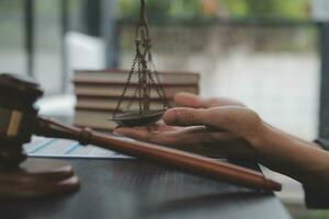 Business and lawyers discussing contract papers with brass scale on desk in office. Law, legal services, advice, justice and law concept picture with film grain effect photo