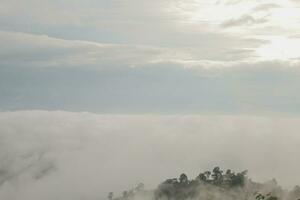 Mountain range with visible silhouettes through the morning blue fog. photo