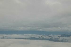 Mountain range with visible silhouettes through the morning blue fog. photo