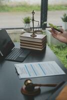 Business and lawyers discussing contract papers with brass scale on desk in office. Law, legal services, advice, justice and law concept picture with film grain effect photo