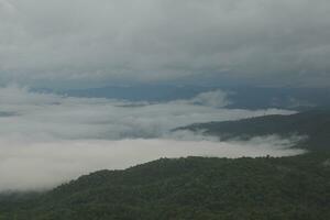 Mountain range with visible silhouettes through the morning blue fog. photo