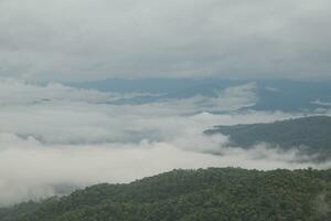 Mountain range with visible silhouettes through the morning blue fog. photo