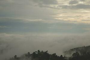 Mountain range with visible silhouettes through the morning blue fog. photo