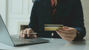 concepto de pago en línea con tarjeta de crédito. mano de hombres que usan una computadora portátil para hacer el pago de un seguro de salud en línea. foto