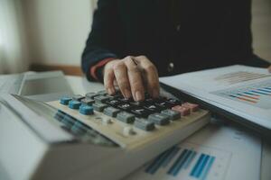 Unrecognizable businessman using calculator photo