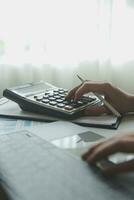 Unrecognizable businessman using calculator photo