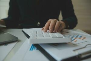 Unrecognizable businessman using calculator photo