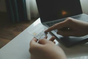 Woman hands holding and using cradit card for shopping online. photo