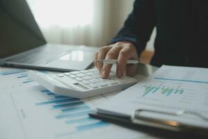 Unrecognizable businessman using calculator photo
