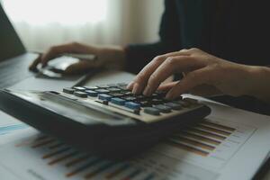 Unrecognizable businessman using calculator photo