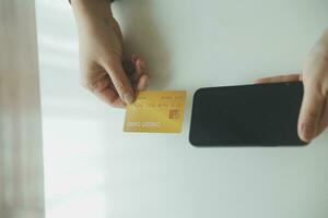 Woman hands holding and using cradit card for shopping online. photo