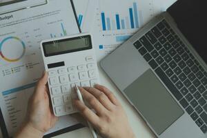 Unrecognizable businessman using calculator photo
