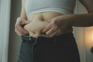 mujer gorda midiendo, mujer gorda gorda vientre gordito panzón deporte recreación cuidado de la salud perder grasa abdominal no hacer ejercicio concepto foto