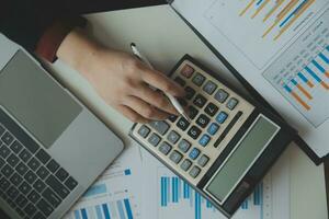 Unrecognizable businessman using calculator photo