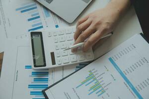 Unrecognizable businessman using calculator photo