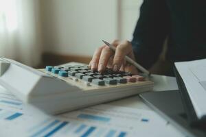 Unrecognizable businessman using calculator photo