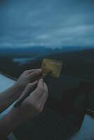 online payment, young woman holding credit card and typing on laptop photo