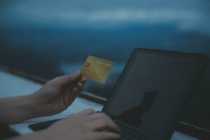 online payment, young woman holding credit card and typing on laptop photo