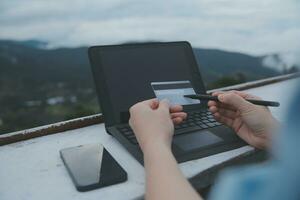 online payment, young woman holding credit card and typing on laptop photo