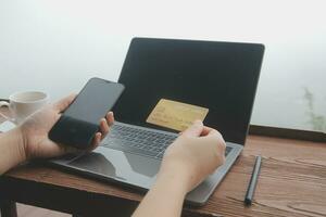 online payment, young woman holding credit card and touching on smartphone screen, copy space photo