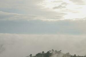 Mountain range with visible silhouettes through the morning blue fog. photo