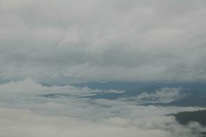 Mountain range with visible silhouettes through the morning blue fog. photo