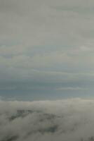 Mountain range with visible silhouettes through the morning blue fog. photo