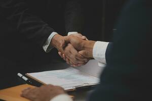 Business and lawyers discussing contract papers with brass scale on desk in office. Law, legal services, advice, justice and law concept picture with film grain effect photo