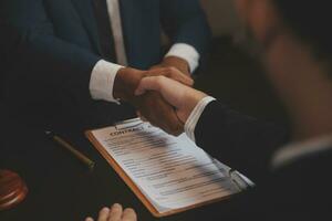 Business and lawyers discussing contract papers with brass scale on desk in office. Law, legal services, advice, justice and law concept picture with film grain effect photo