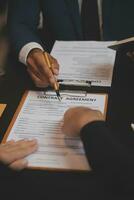 Business and lawyers discussing contract papers with brass scale on desk in office. Law, legal services, advice, justice and law concept picture with film grain effect photo